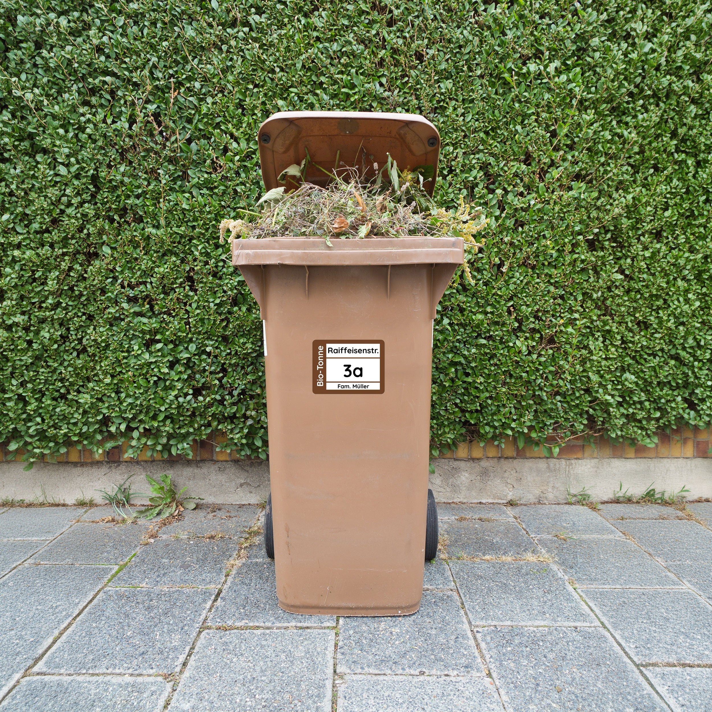 Vier wetterfeste Mülltonnenaufkleber in 19x14 cm, individuell gestaltbar, mit bunten Symbolen auf der Mülltonne.