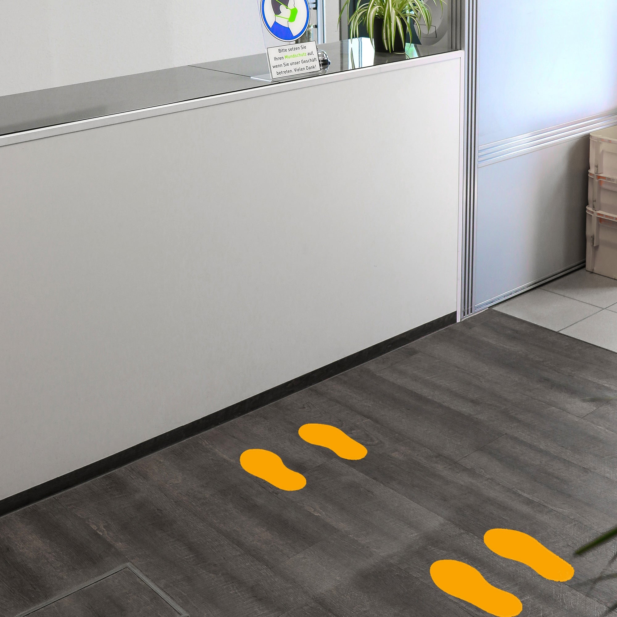 Gelbe Fußbodenaufkleber für Fußpaare, 10 Paar, Größe 250x110 mm, von aufkleberdrucker.de auf glatter Oberfläche sichtbar.